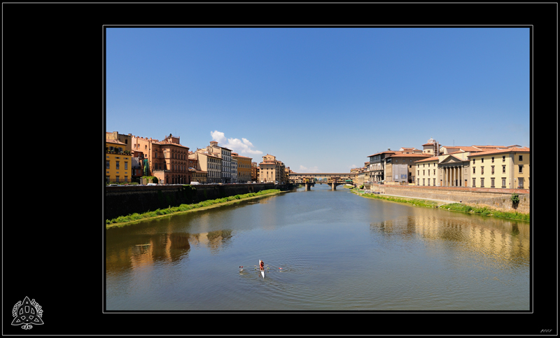 Zwei linksmittig unten platzierte Ruderer in einem Ruderboot auf einem Fluss namens Arno in der