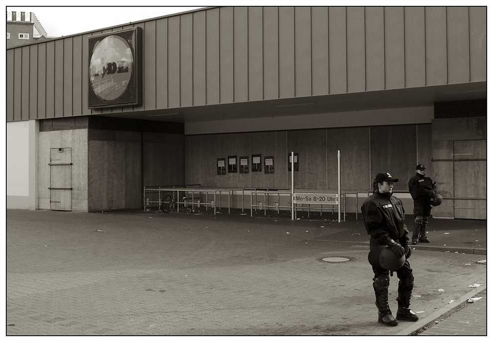 zwei Uniformierte die einen Supermarkt bewachen